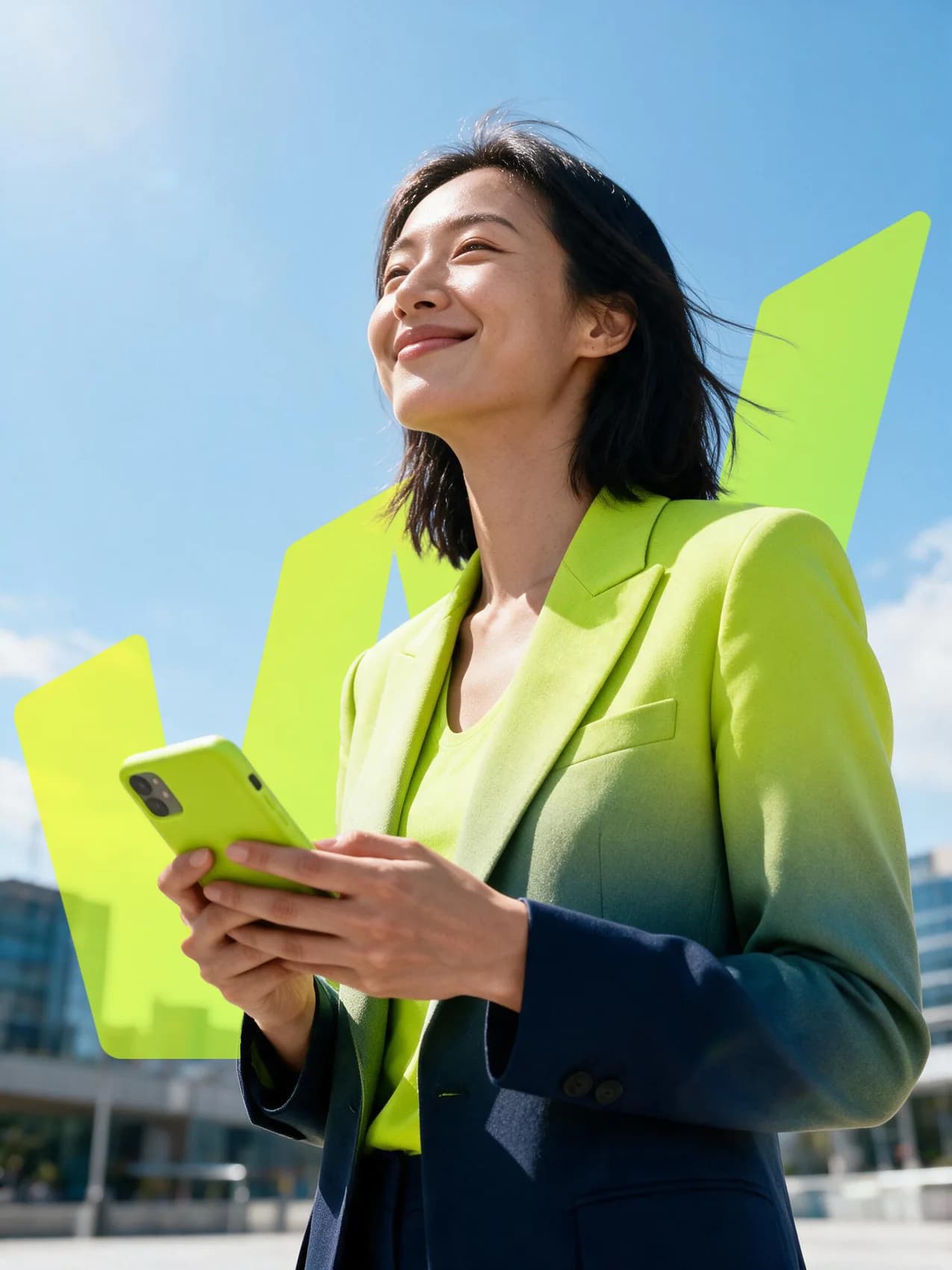 Una mujer con traje formal sostiene su teléfono al aire libre, con edificios de oficinas al fondo bajo un cielo despejado.